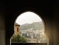 GRANADA, SPAIN - FEBRUARY 10, 2015: A view to old white houses of Granada over the hill through a decorated window Royalty Free Stock Photo