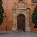 GRANADA, SPAIN - SEPTEMBER 25, 2021: Homeless sitting on the medieval door of a church in Granada