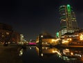 the granary wharf area of leeds caal at night with illuminated buildings reflected in the water with locks cranes and bridgewater