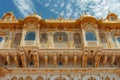 A grand building displaying exquisite gold trimmings and adorned with multiple windows, An Indian palace with gold embellishments
