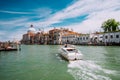 Grand Canal tourist boat with Basilica Santa Maria della Salute against blue sky and white clouds, Venice, Italy Royalty Free Stock Photo