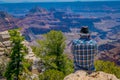 Grand Canyon,Arizona USA, JUNE, 14, 2018: View of unidentified man wearing a plaid shirt and hat, using his cellphone in Royalty Free Stock Photo