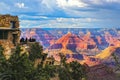 Grand Canyon South Rim view at golden hour under stormy sky with tourists at lookout point taking pictures and selfies Royalty Free Stock Photo