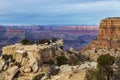 Grand Canyon, view from Moran Point. Rocks and trees in foreground; canyon with cloudy sky behind. Royalty Free Stock Photo