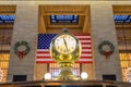 Grand CentralÃ¢â¬â¢s Main Concourse Clock in New York. Famous Golden Structure. United States of America Flag in Background