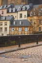 A typical cobblestone road in central Luxembourg City with fortress wall behind & old traditional tall houses with mansard roof Royalty Free Stock Photo