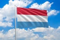 Luxembourg national flag waving in the wind on clouds sky. High quality fabric. International relations concept Royalty Free Stock Photo