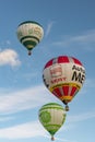 Blue sky and clouds with three colourful hot-air balloons
