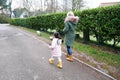 Grand mother and grandchild little girl walking together with the dogs in the countryside suburb area