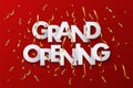 Grand Opening white paper words with golden serpentines and confetti on red background. Vector design template.