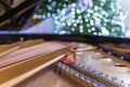 The grand piano interior with visible strings In the background a blurred Christmas tree, ornaments and lights Royalty Free Stock Photo