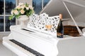 Grand piano in a luxury white classic interior with wine, palms and flowers. Royalty Free Stock Photo