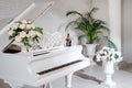 Grand piano in a luxury white classic interior with wine, palms and flowers. Royalty Free Stock Photo