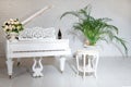 Grand piano in a luxury white classic interior with wine, palms and flowers. Royalty Free Stock Photo