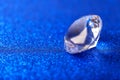 Grand royal pure diamond on blue sparkling sequins background, macro . Big brilliant closeup Royalty Free Stock Photo