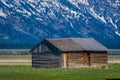 Grand Teton National Park, Wyoming. Wood Cabin on a Golden Grass Prairie against the Grand Teton Mountains.