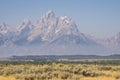 Grand Teton rising above mist, field, and trees. Royalty Free Stock Photo