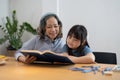 grandchild granddaughter grandma grandmother reading book girl senior. asian people. Royalty Free Stock Photo