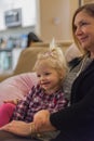 Little girl snuggling family member on couch Royalty Free Stock Photo