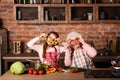 Grandchild with granny holding slices of pepper