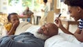 Grandchildren Drawing On Sleeping Grandfather's Head With Marker Pen At Home Royalty Free Stock Photo