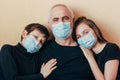 Grandchildren in face masks leaned on grandfather`s shoulders and afraid of the consequences of the pandemic. Quarantined due to