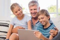 Grandchildren with grandfather using tablet Royalty Free Stock Photo