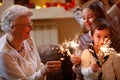 Grandchildren and grandparents with sprinklers celebrating xmas