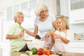 Grandchildren Helping Grandmother To Prepare Salad Royalty Free Stock Photo