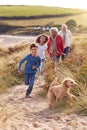 Grandchildren And Pet Dog Exploring Sand Dunes With Grandparents On Winter Beach Vacation Royalty Free Stock Photo