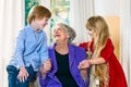 Grandchildren visiting their elderly grandmother