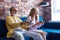 Granddad granddaughter enjoy videogames sit on couch at home