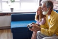 Granddad granddaughter enjoy videogames sit on couch at home