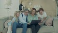 Granddad and grandma are playing on a laptop with grandkids