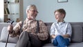 Granddad and grandson laughing genuinely, joking, valuable fun moments together Royalty Free Stock Photo