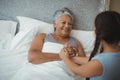 Granddaughter comforting sick grandmother in bed room Royalty Free Stock Photo