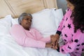 Granddaughter comforting sick grandmother in bed room Royalty Free Stock Photo