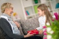 Granddaughter giving gift to her grandmother Royalty Free Stock Photo