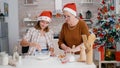 Granddaughter with granddaughter breaking egg in kitchen bowl with flour ingredient