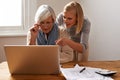 Granddaughter, grandmother and help with laptop for online payment, finance and technology with advice on budget. Women Royalty Free Stock Photo