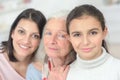 Granddaughter grandmother and mother standing in row