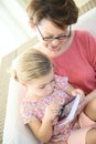 Granddaughter and grandmother playing on a tablet Royalty Free Stock Photo