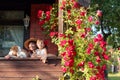 Granddaughter, grandmother and their dog on the veranda of the village house