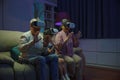 Granddaughter and grandparents playing together exciting interesting video games using virtual reality headsets Royalty Free Stock Photo