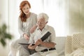 Granddaughter and happy grandfather watching photo album during