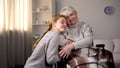Granddaughter hugging handicapped grandmother, family kindness, volunteering