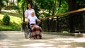 Granddaughter pushing old woman in wheelchair hospital garden, support and care Royalty Free Stock Photo