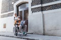 Granddaughter pushing senior man in wheelchair on street. Buying newspaper in newsstand. Female caregiver and elderly Royalty Free Stock Photo