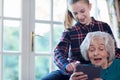 Teenage Granddaughter Showing Grandmother How To Use Digital Tab Royalty Free Stock Photo