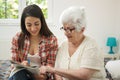 Granddaughter solving crosswords puzzle with the help of her grandmother at home Royalty Free Stock Photo